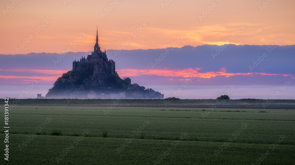 Beautiful panoramic view of famous Le Mont Saint-Michel tidal island at sunrise. Normandy, northern France