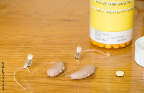 Close up of a pair of tiny modern hearing aids with prescription drug photo