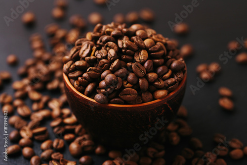 Roasted coffee beans scattered around. Gray background. Horizontal view