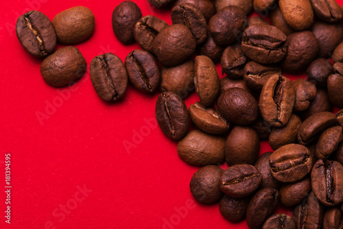 Roasted coffee beans on red background. Color surge trend. photo