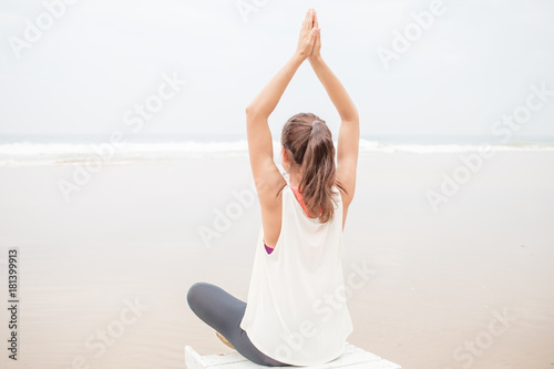 Woman practices yoga at the seashore on overcast day © Maygutyak
