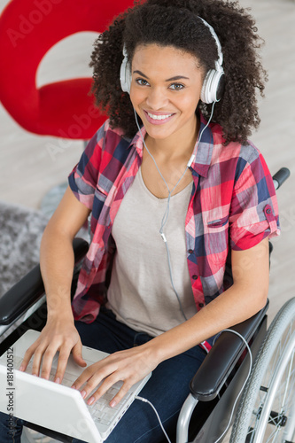 confident disabled woman using laptop at desk in creative office