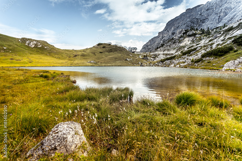 Small dolomitic  lake with mountain hut background, Valparola Pass, Dolomites, Italy
