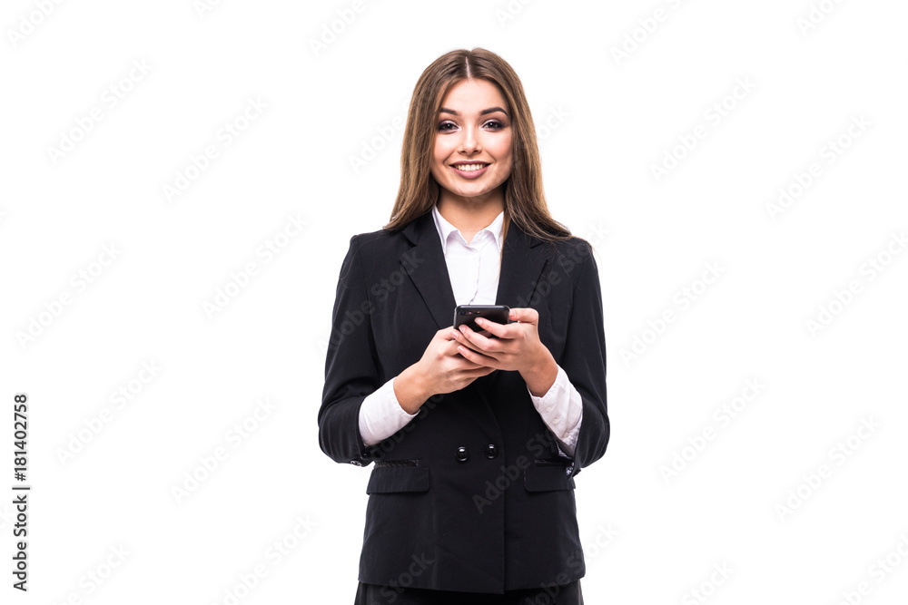 Beautiful young businesswoman holding mobile phone and looking at camera while standing against grey background Beautiful young businesswoman holding mobile phone and looking at camera while standing against grey background