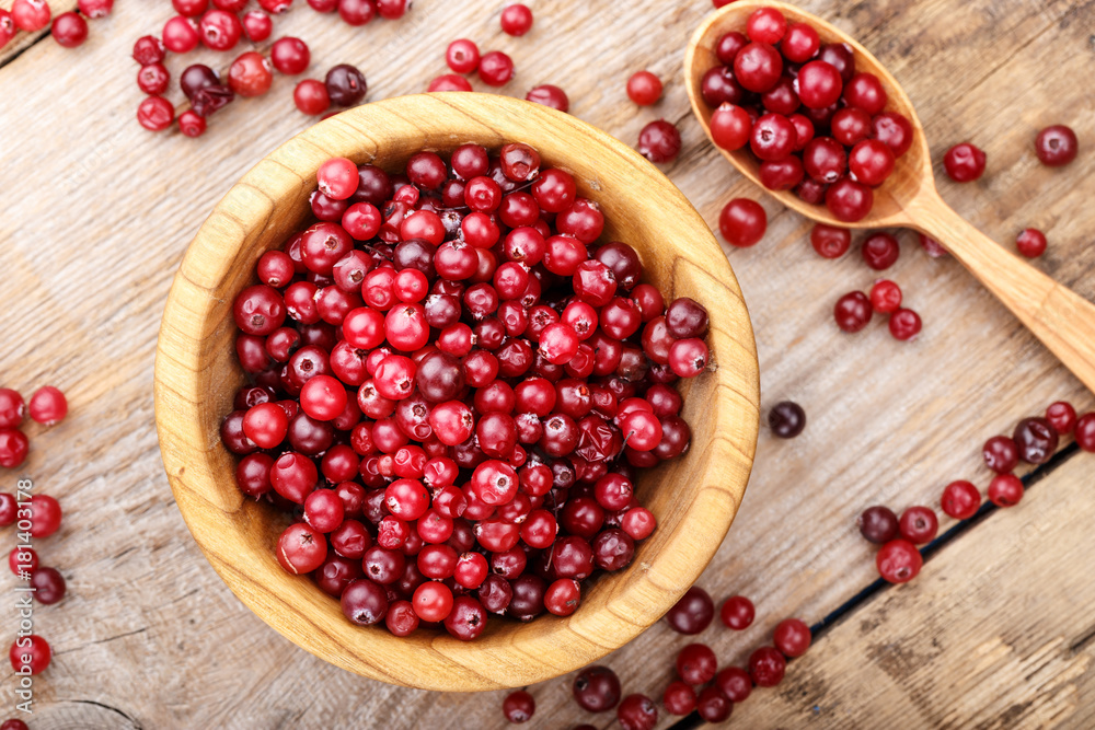 cranberries in a plate on a wooden background cranberries in a plate on a wooden background