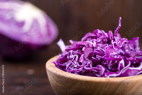 cuted purple cabbage on a wooden background in a plate, top view, a healthy vegetarian product.