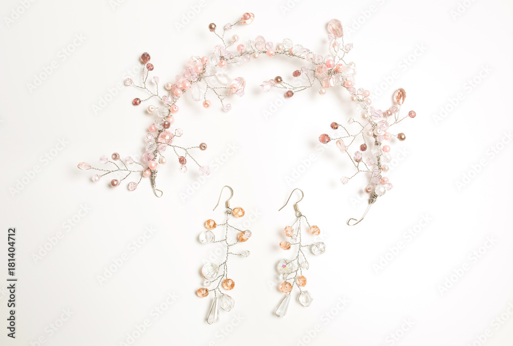 Beautiful hair accessory and earrings decorated with white and pink beads over a white background Beautiful hair accessory and earrings decorated with white and pink beads over a white background