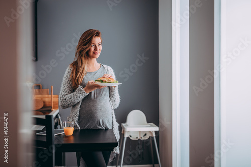 Young pregnant woman eating her breakfast photo