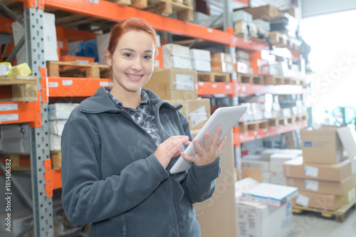 Young warehouse worker holding tablet