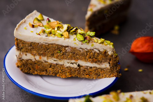 Paleo raw vegan pistachio carrot cake with cashew cream layers. Dark food photography concept