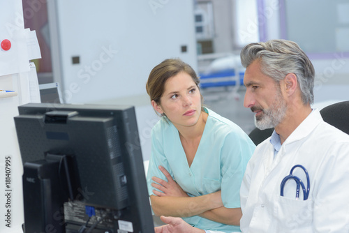 doctor and young female nurse checking patient documents © auremar