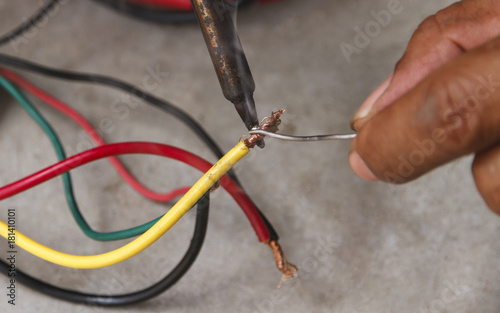 Assembling works soldering iron wires.