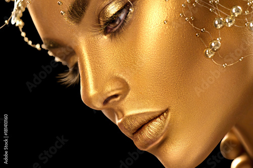 Beauty model girl with holiday golden shiny professional makeup closeup portrait. Gold  jewelry and accessories