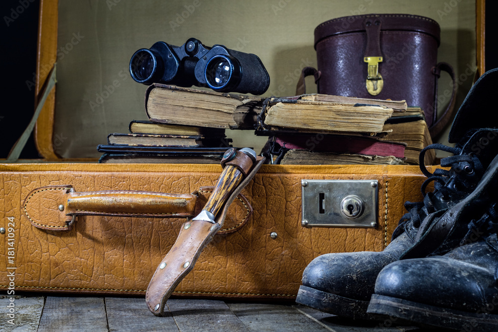 Old stylish suitcase. Old books in a suitcase. Suitcase on a wooden table. Old stylish suitcase. Old books in a suitcase. Suitcase on a wooden table.