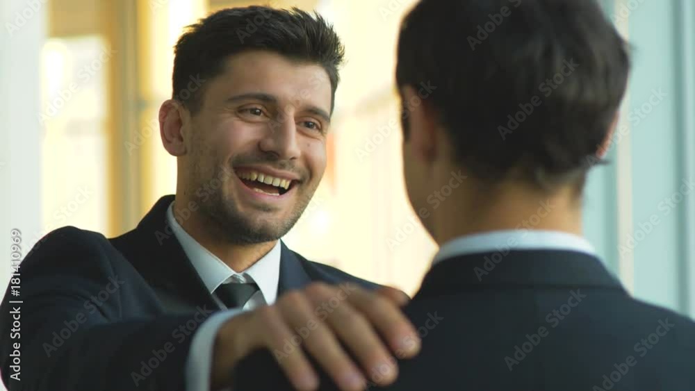 The businessmen pat on the shoulder in the office. slow motion