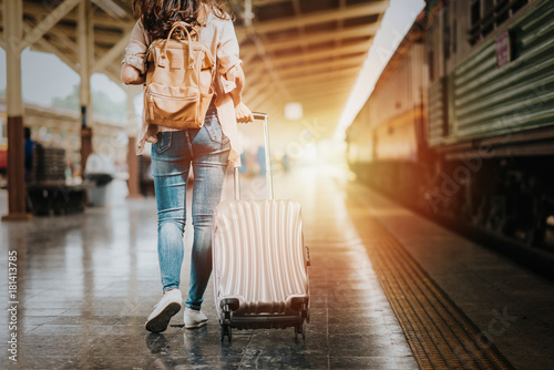 Woman traveler tourist walking with luggage at train station. Active and travel lifestyle concept photo