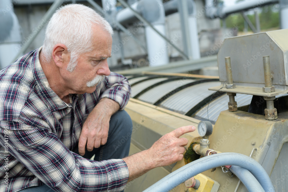 man reading the pressure gauge man reading the pressure gauge