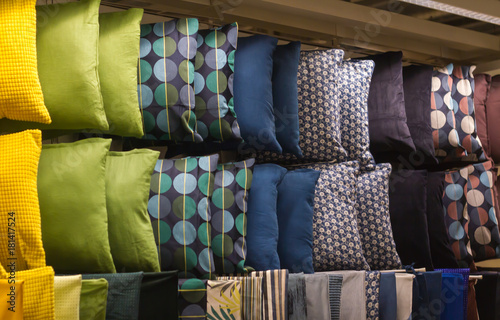 Many samples bright color pillow hanging on shelf in store, colored background