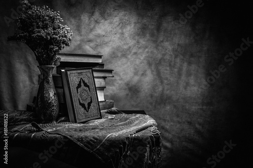 Koran - holy book of Muslims ( public item of all muslims ) on the table , still life  Monochrome or black and white