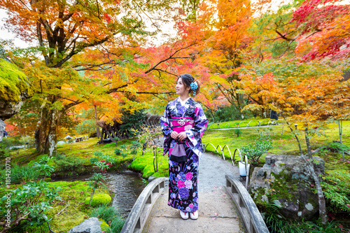 Photography Asian woman wearing japanese traditional kimono in autumn park.