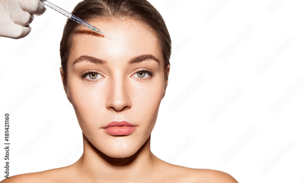 Close-up portrait of a woman with syringe near her face. Young woman gets beauty injection in her face. isolated on white. Beauty skin care, facial treatment and cosmetology concept.