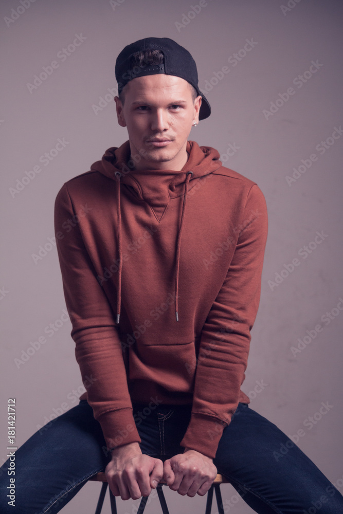 one young man, early 20s, boyish looks, posing in studio, casual clothes, sweatshirt cap, upper body shot one young man, early 20s, boyish looks, posing in studio, casual clothes, sweatshirt cap, upper body shot