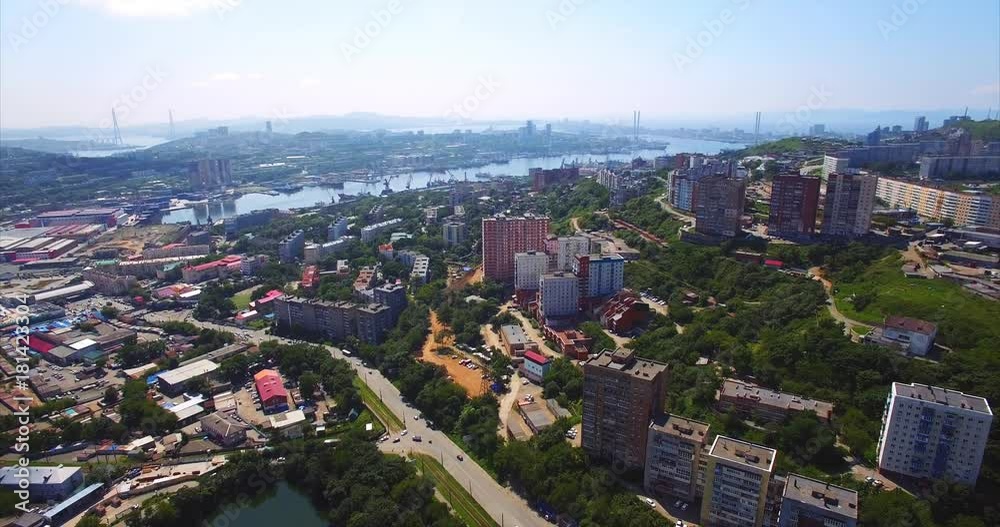 Flying backwards above Vladivostok residential district with streets, houses, Mine Park (Minny Gorodok) with lakes. Aerial view of the Golden horn harbour on the background. Summer day. Russia Flying backwards above Vladivostok residential district with streets, houses, Mine Park (Minny Gorodok) with lakes. Aerial view of the Golden horn harbour on the background. Summer day. Russia