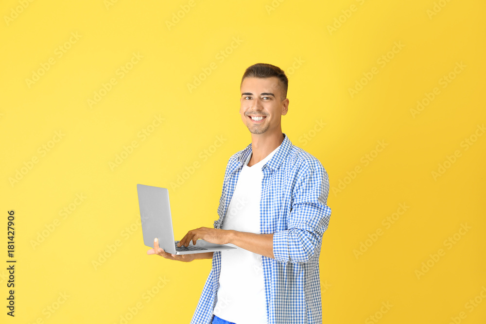 Young man with laptop on color background Young man with laptop on color background