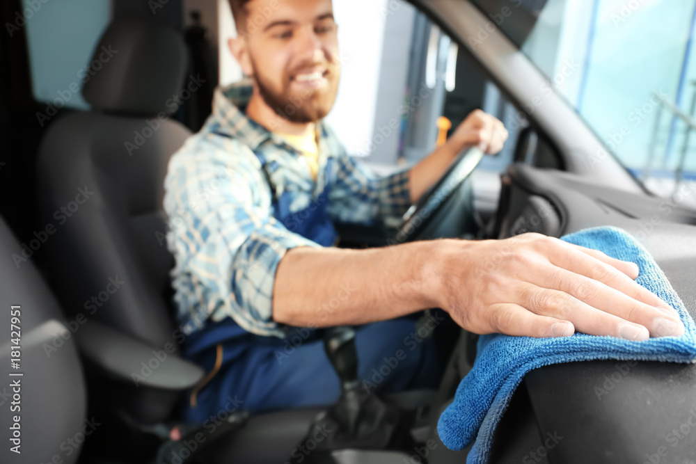 Man cleaning salon with rag in car Man cleaning salon with rag in car