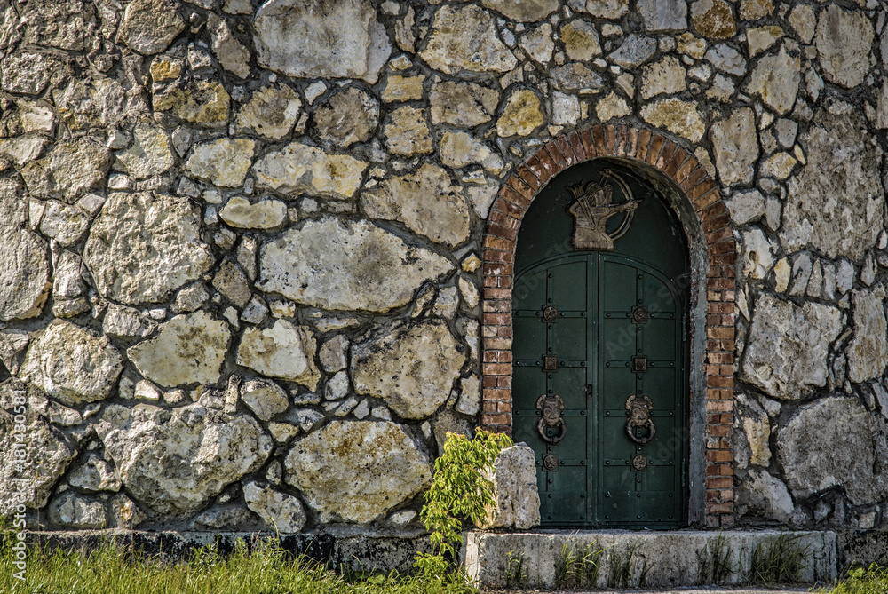 Wooden door to the tower of a stone fortress.