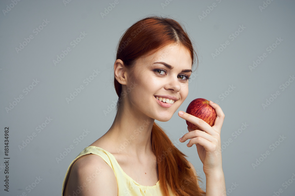 Fruit, portrait, healthy eating, meal, young beautiful woman on a gray background holding an apple, smile Fruit, portrait, healthy eating, meal, young beautiful woman on a gray background holding an apple, smile
