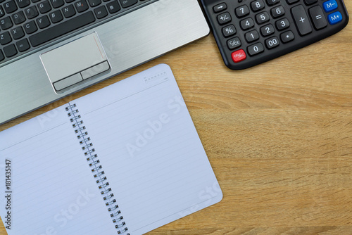 Laptop computer or notebook and other device, calculator and note on working table with copy space top view.