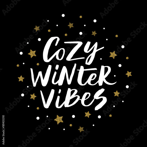 Cozy winter vibes - trendy brush hand lettering isolated on black background with gold glitter stars. Greeting card for the winter season. Round element for your design. Vector illustration.