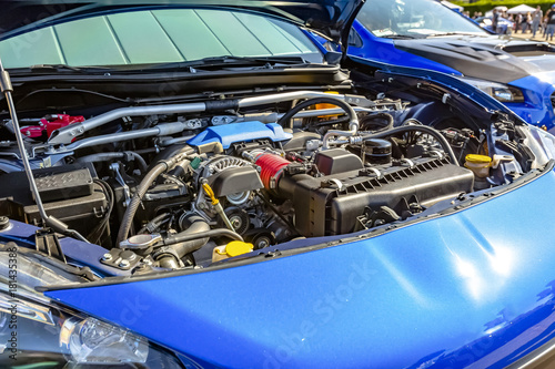 Engine under the hood of a modern blue car