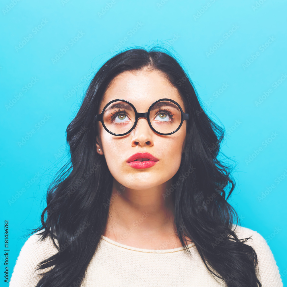 Young woman looking upward on a solid background Young woman looking upward on a solid background