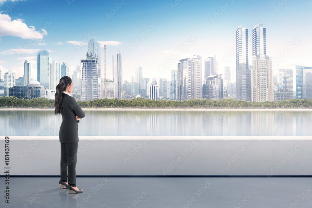 Portrait of asian business woman standing on terrace and looking modern cityscape Portrait of asian business woman standing on terrace and looking modern cityscape