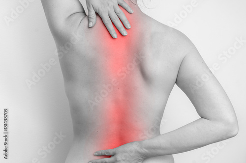 Woman with spine pain is holding her aching back photo