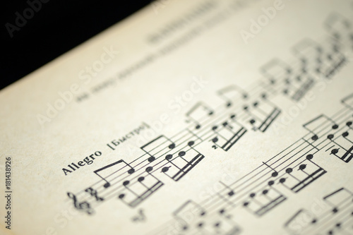 Musical tempo "Allegro" in an old music notebook close up