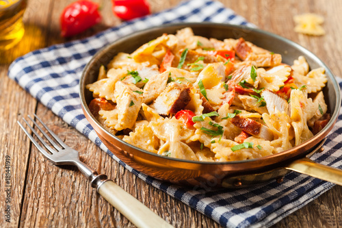 Pasta farfalle with chicken and paprika, in carbonara sauce.