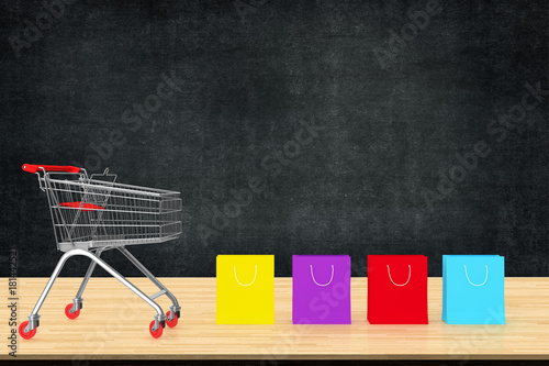 Colorful paper shopping bags with trolley on wood table with black board backdrop. Ideas about online shopping, E-commerce online business. copy space for art work design or add text message.