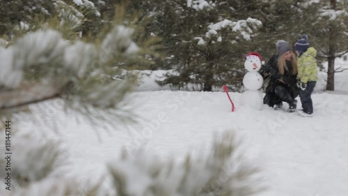 Mom and son make a snowman 13 Happy mother and son make a snowman falling fluffy snow