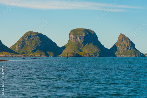 Scenic rocky coastline of island Rost in Norway with houses and old lighthouse
