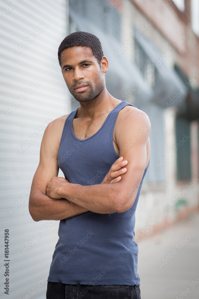 Young handsome African American man with arm crossed in the rough neighborhood