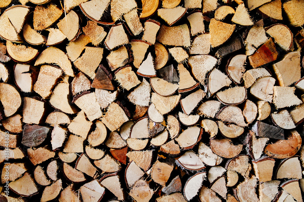 Stack of round and square natural firewood in preparation for the winter and used for camp fires, fireplaces and home heating. Chopped and piled wood background texture. Stack of round and square natural firewood in preparation for the winter and used for camp fires, fireplaces and home heating. Chopped and piled wood background texture.