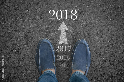 Man feet on asphalt road with start new year 2018 concept.