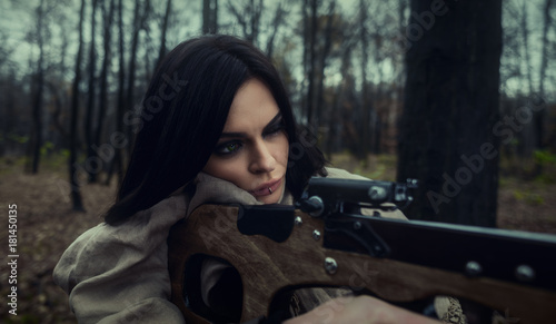 Foto Girl with a crossbow in the forest. Autumn forest.