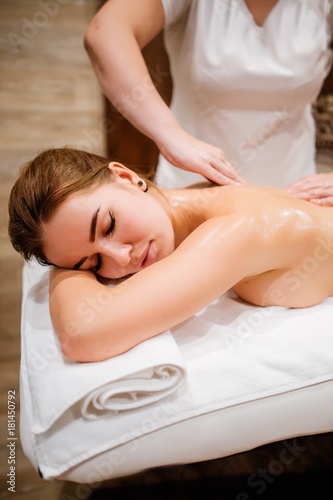 Masseur woman back rubs girls massage oil in preparation for the procedure