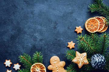 Winter holidays Christmas or New Year background with gingerbread cookies, fir tree and dried orange rings. Copy space for your text. Design mock up