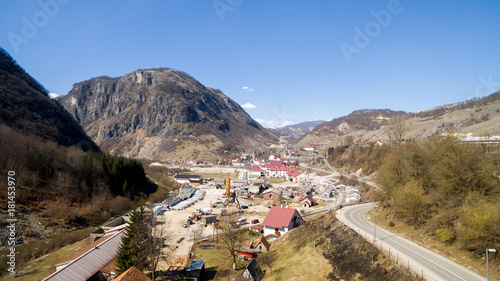 village with red roofs near road and mountains on  clear day