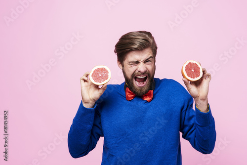 Screaming man holding sour fruit photo